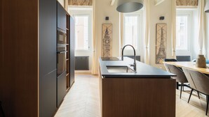 A modern kitchen with a central island, built-in appliances, and large windows. - THE BREAK - CAMPO MARZIO MAISON DELUXE (Roma)