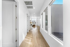 A hallway with wooden flooring, white walls, and large windows. - Tee for Two at Bloomington Country Club: Reunion Property, Pool, Golf (St. George)