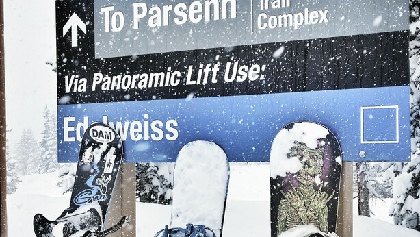 A signpost with directions to various ski resorts and a panoramic lift system. Snowboards are leaning against the signpost. - Beautiful multilevel townhome downtown Winter Park w/private rooftop hot tub (Winter Park)