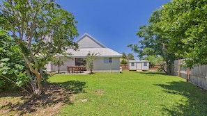 A house with a sloped roof, a fenced backyard, and a small shed.