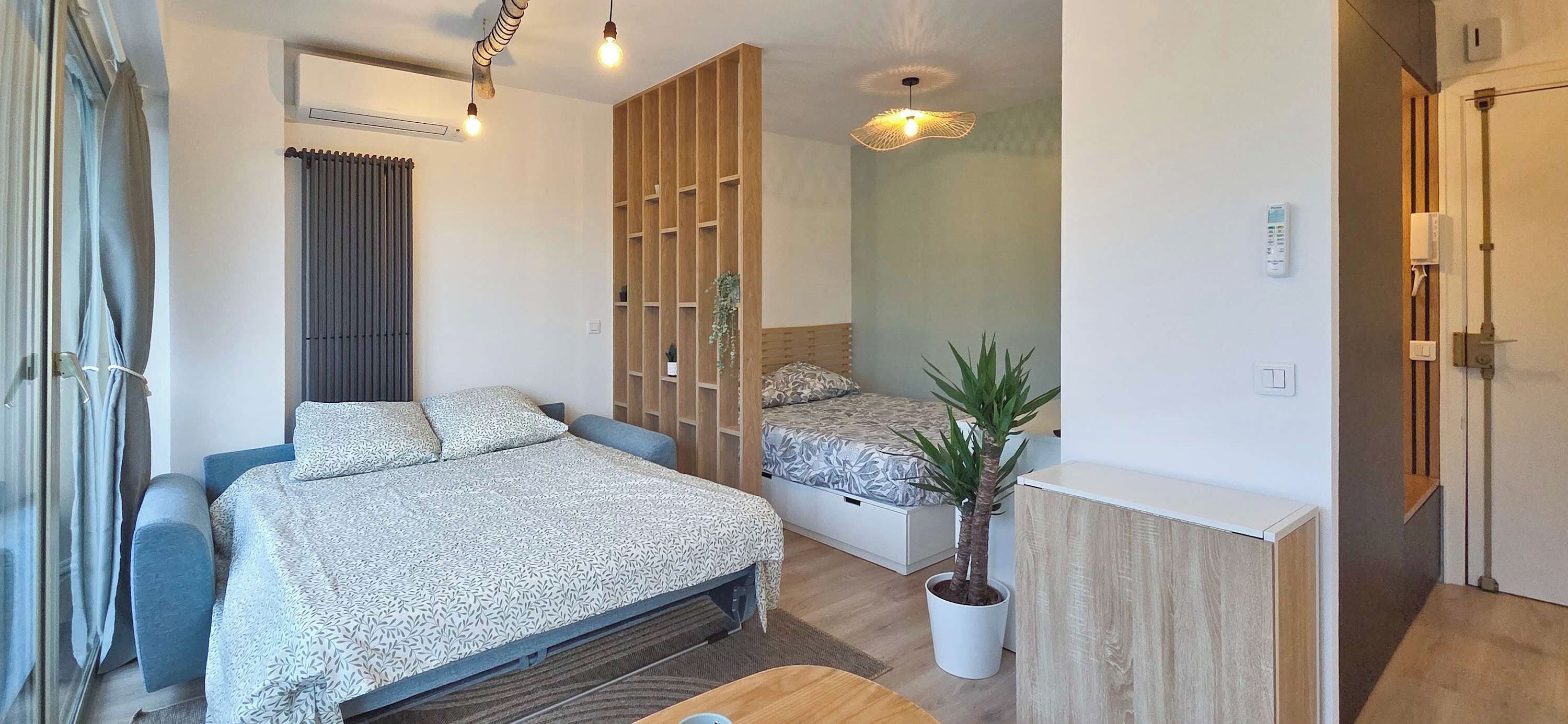 Quarto moderno com cama, escrivaninha e planta em vaso.