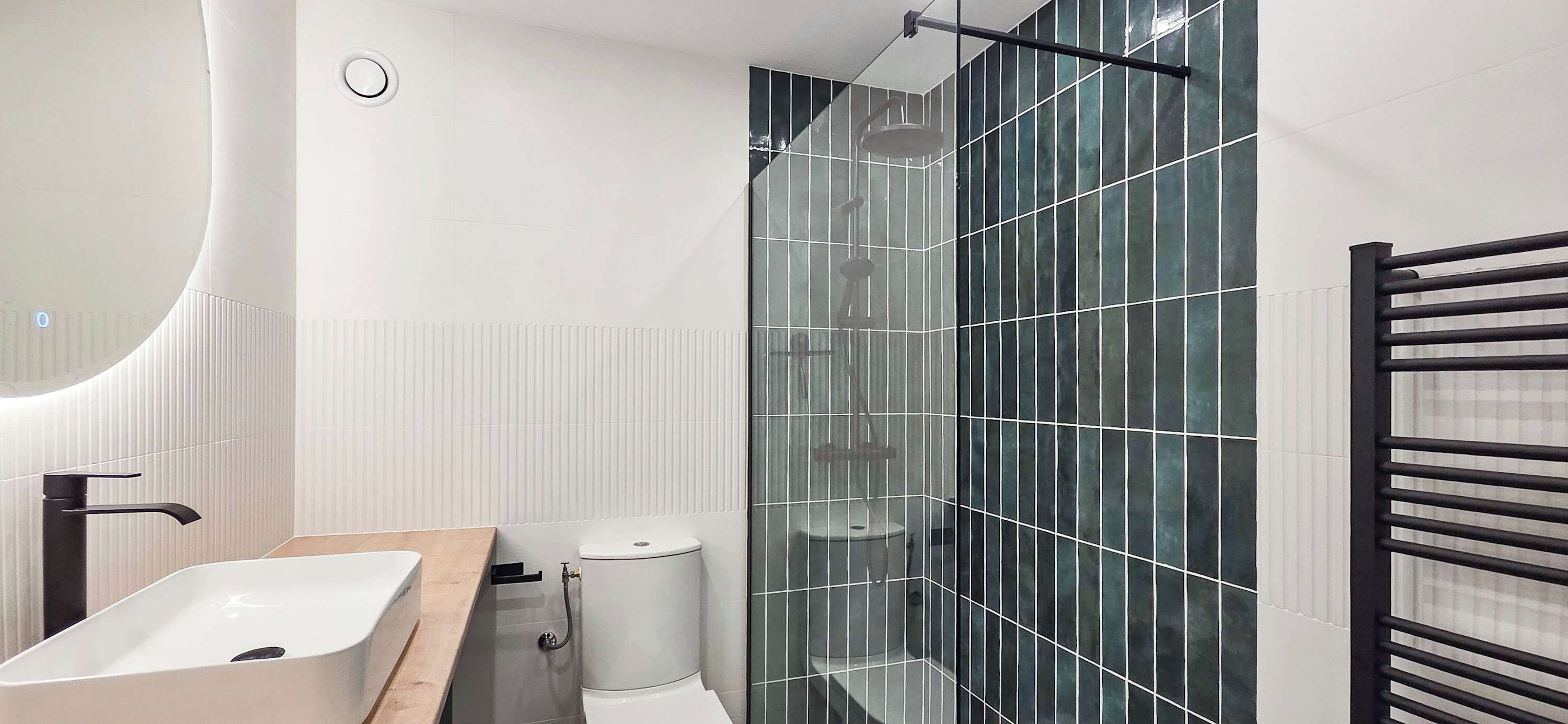 Ein modernes Badezimmer mit Waschbecken, Toilette und einer Duschkabine.
