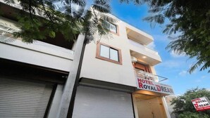 Un bâtiment à deux étages avec une porte de garage fermée et une enseigne indiquant « Hôtel Royal Dream ».