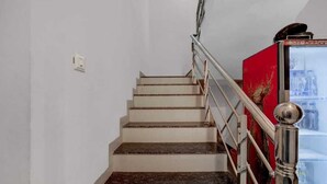 Un escalier avec une rampe en métal et un panneau décoratif rouge sur le côté droit.