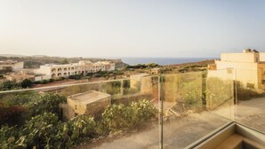 A rooftop terrace with a clear view of the surrounding buildings and the sea. - Gozo Haven With Pool Views in Nadur for Families (Nadur)