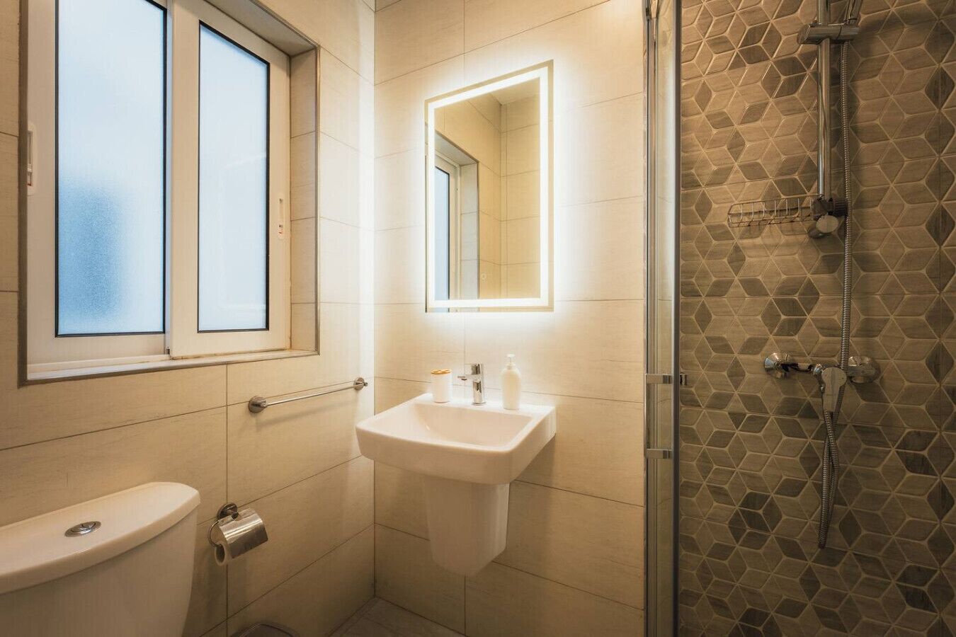 Une salle de bain avec des toilettes, un lavabo et une douche.