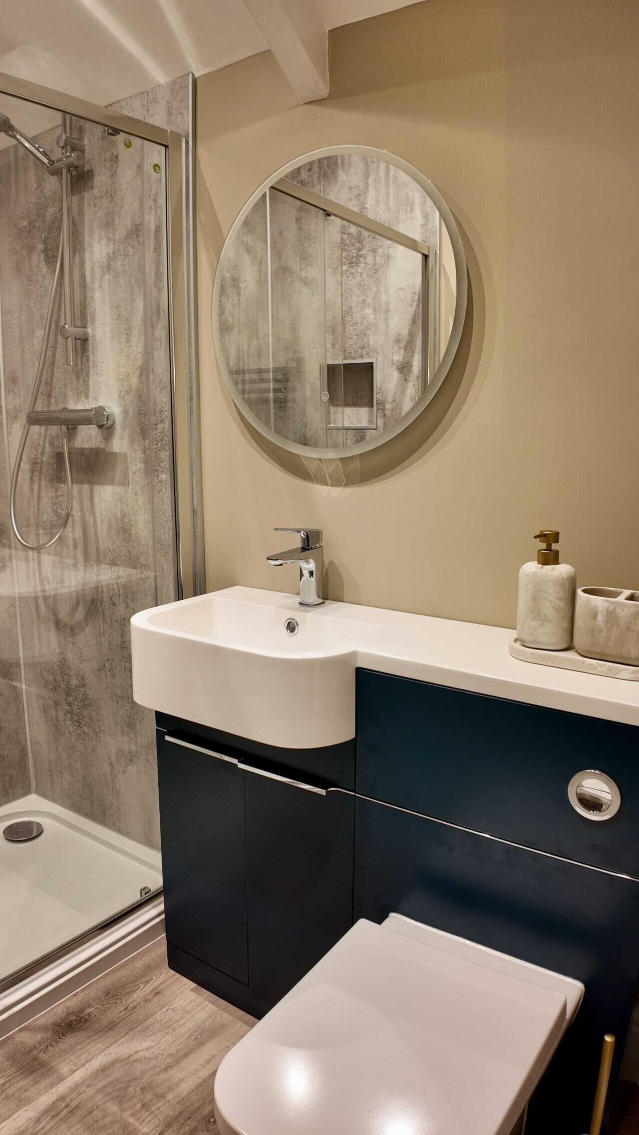 Un bagno moderno con doccia, lavandino e WC.