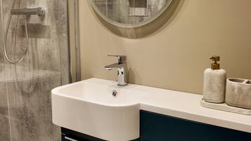 Un bagno moderno con doccia, lavandino e WC.