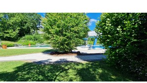 A park with a playground, a tree, and a paved walkway. - Maisonette-traum mit Dachterrasse und Panorama (Willingen)