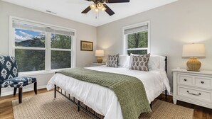 A bedroom with a bed, nightstands, a chair, and a ceiling fan. - Ridgeview Retreat with Firepit and Mountain Views (Barnardsville)