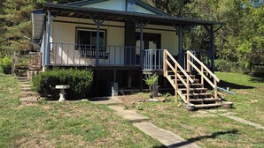 A small, single-story house with a porch and a staircase leading to the entrance. - Pet-friendly cottage bordering Shawnee State Forest.  Minutes from Shawnee State Park, Roosevelt Lake, Turkey Creek Lake, nature center, and hiking trails. (West Portsmouth)