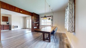 A spacious kitchen with wooden cabinets, a dining table, and pendant lights. - Pet-friendly cottage bordering Shawnee State Forest.  Minutes from Shawnee State Park, Roosevelt Lake, Turkey Creek Lake, nature center, and hiking trails. (West Portsmouth)