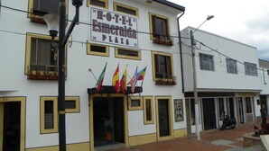 A hotel named "HOTEL E. L. Esmeralda PLAZA" with a white facade, yellow trim, and multiple windows. Flags are displayed outside. - Hotel Esmeralda Plaza (Zipaquirá)