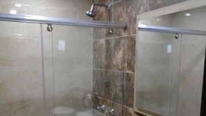 A modern bathroom with a glass shower enclosure, a white toilet, and a granite countertop with a sink. - Hotel Esmeralda Plaza (Zipaquirá)