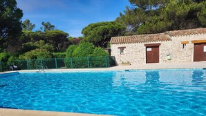 Une piscine d’eau cristalline, avec un bâtiment en pierre en arrière-plan.