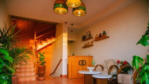 Um interior aconchegante com escada, móveis de madeira e plantas em vasos.