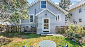 A house with a front porch, a small patio, and a fenced backyard. - Brunswick 3BR Bungalow By Bowdoin With Fenced-In Backyard (Brunswick)