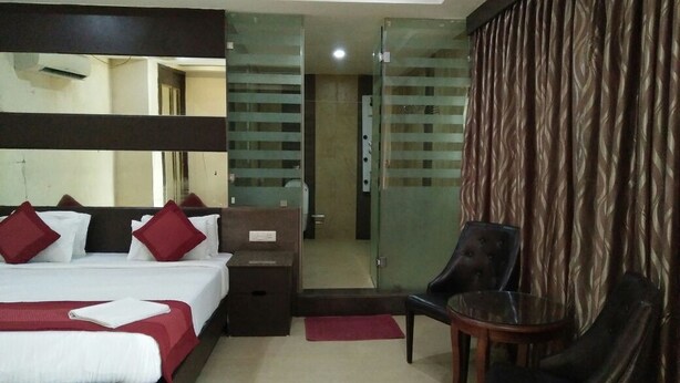 A hotel room with a bed, a desk, a chair, and a mirror. - BAGA RESIDENCY (Calangute)