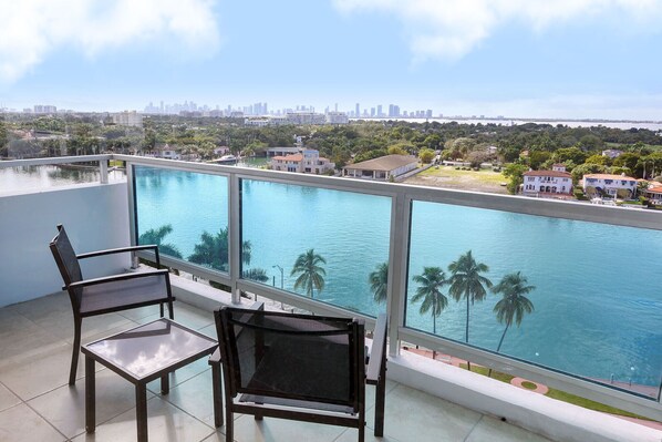 A balcony with a view of a city skyline and a body of water.