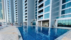Una piscina circondata da moderni grattacieli con balconi.