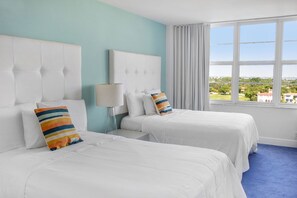 A hotel room with two beds, a window with a view, and a lamp. - 2bd Beachfront Master Ste, Bay View w/balcony, Pool, nearby dining, beach access (Miami Beach)