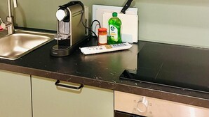 A kitchen with a sink, a coffee maker, a cutting board, a bottle of dish soap, and a jar of pasta sauce. - Casa Sforza - stylish apartment in the heart of Bergamo! (Bergamo)