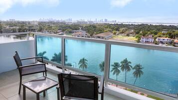 A balcony with a view of a city skyline and a body of water.