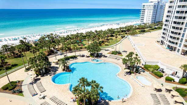 Ein Resort mit einem zentralen Schwimmbad, Zugang zum Strand und Blick auf den Ozean.