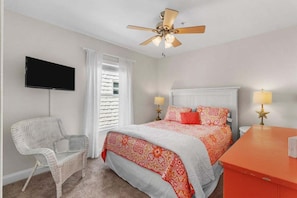 A bedroom with a bed, a chair, a television, and a ceiling fan. - Amazing Views. 3BR. Walk to Pier. (Carolina Beach)
