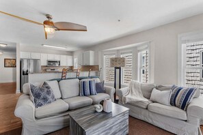 Un salon moderne avec un canapé, une table basse et un ventilateur de plafond.