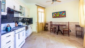 A kitchen with white cabinets, a stove, and a ceiling fan. - Ocean Front, Direct Access to the Beach! (Sosúa)