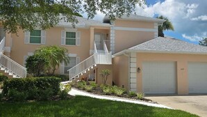 A two-story house with a front porch, a garage, and a well-maintained lawn.
