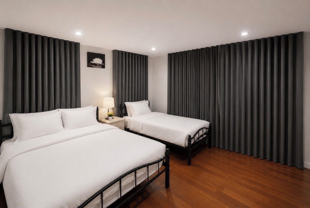 Une chambre d’hôtel avec deux lits, une table de chevet, une lampe et un tableau accroché au mur.