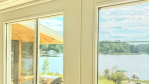 A sign that reads "ON LAKE TIME" above a window with a view of a lake.