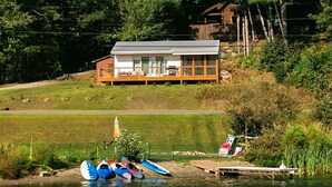 A lakeside cabin with a deck and a dock.