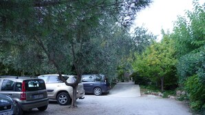 A parking area with several cars parked under trees. - Villa 75m² classified 2*, close to shops equipped with mosquito repellent (Sanary-sur-Mer)