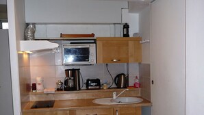 A compact kitchen with a microwave, coffee maker, and sink. - Villa 75m² classified 2*, close to shops equipped with mosquito repellent (Sanary-sur-Mer)