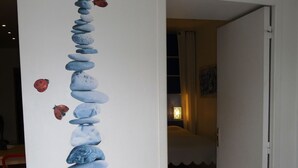 A hallway with a wall-mounted art installation of stacked stones and ladybugs. - Villa 75m² classified 2*, close to shops equipped with mosquito repellent (Sanary-sur-Mer)