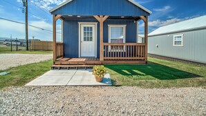 A small, single-story house with a porch, a front door, and a small window. - Charming 1-bedroom cottage on historic Rt. 66 on the west side of Yukon. (El Reno)