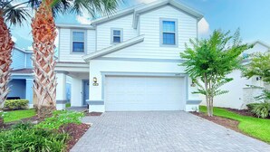 A two-story house with a white exterior, a garage, and a paved driveway.
