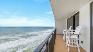 A balcony with a view of the ocean, white chairs, and a table. - ☀️ Ocean Front - Sherwin Condominium 1702 ☀️ (Daytona Beach Shores)