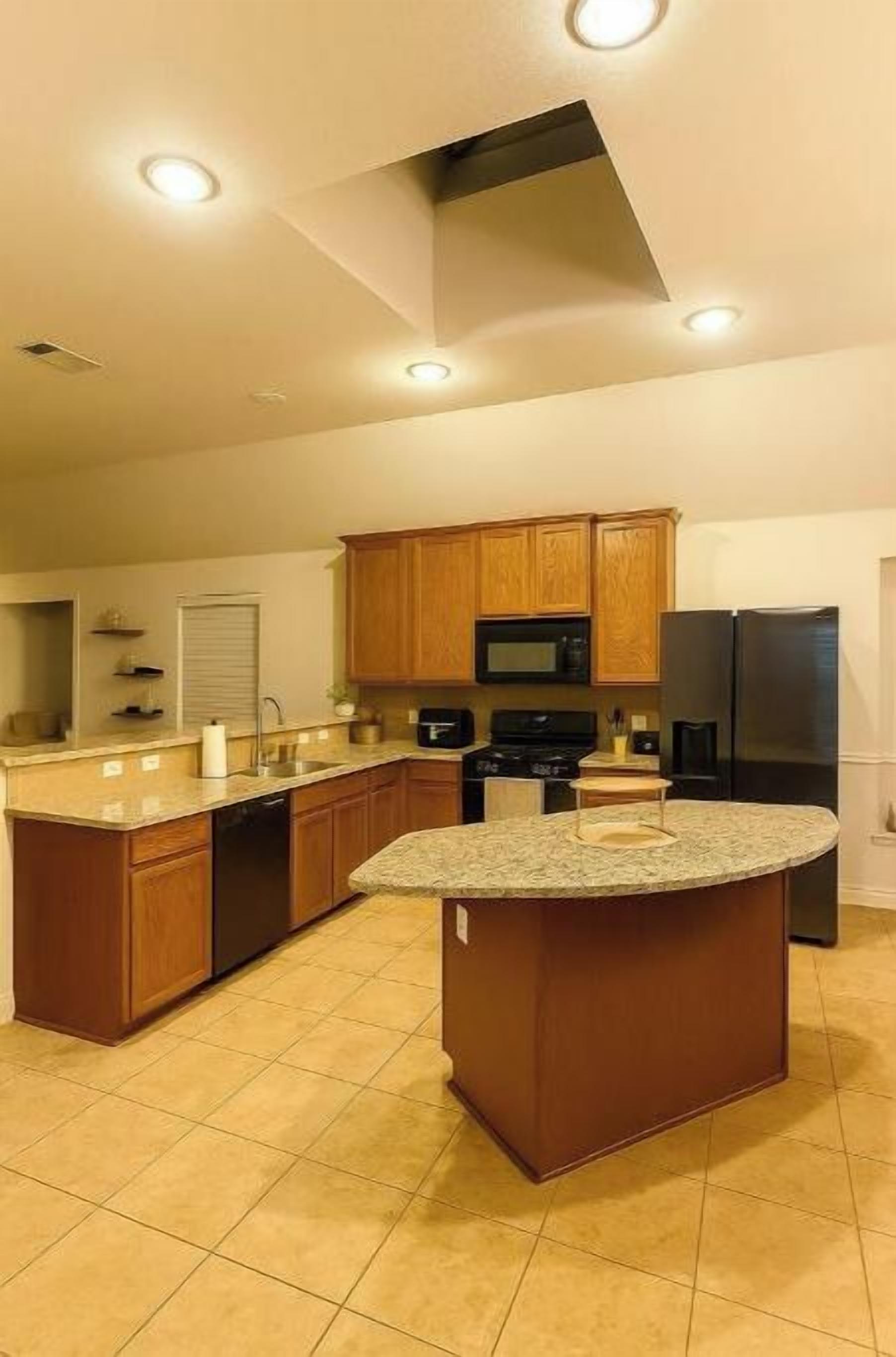 Una cocina moderna con armarios de madera, una isla central y electrodomésticos empotrados.