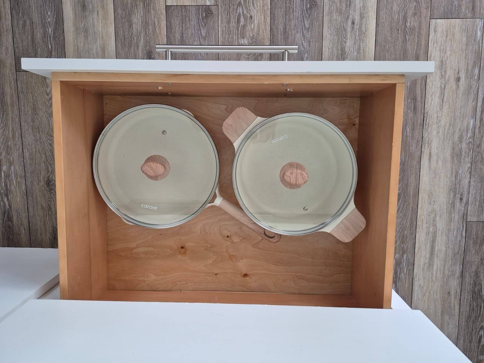 A wooden drawer with two glass containers labeled 'carote'.
