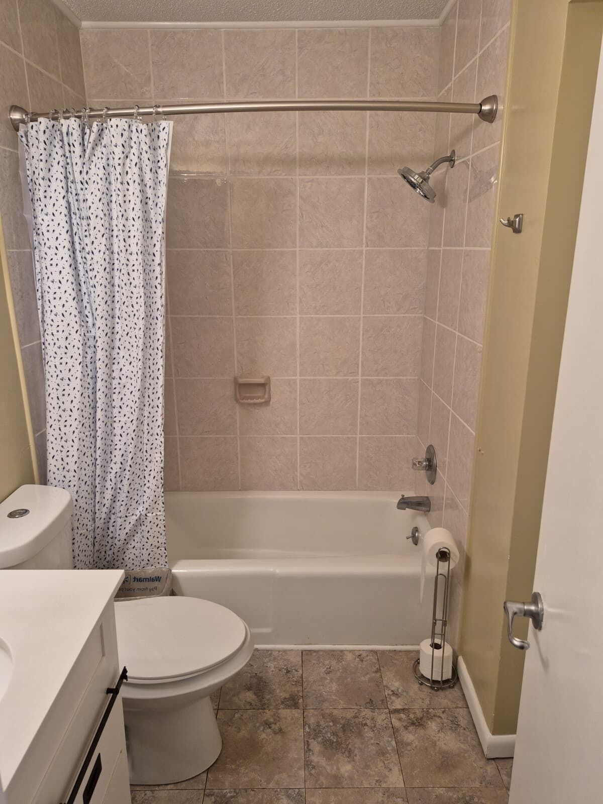 A bathroom with a bathtub, toilet, and shower curtain.