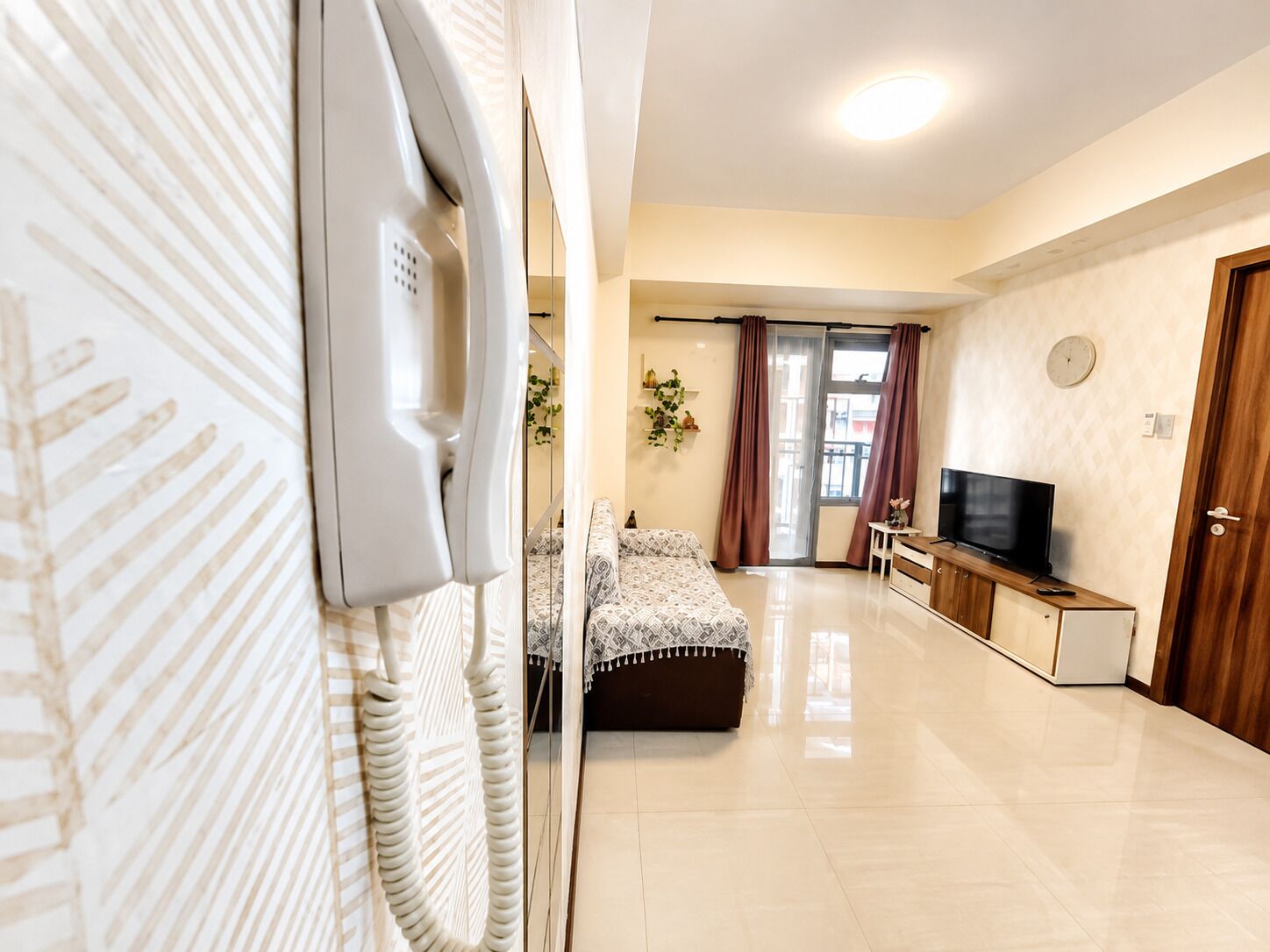 Ein Hotelzimmer mit einem Bett, einem Fernseher, einem Schreibtisch und einer Tür.