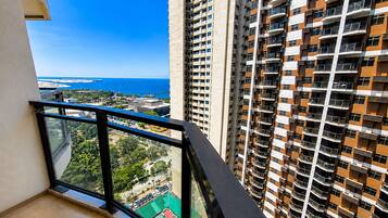 A high-rise building with a balcony overlooking a coastal area.