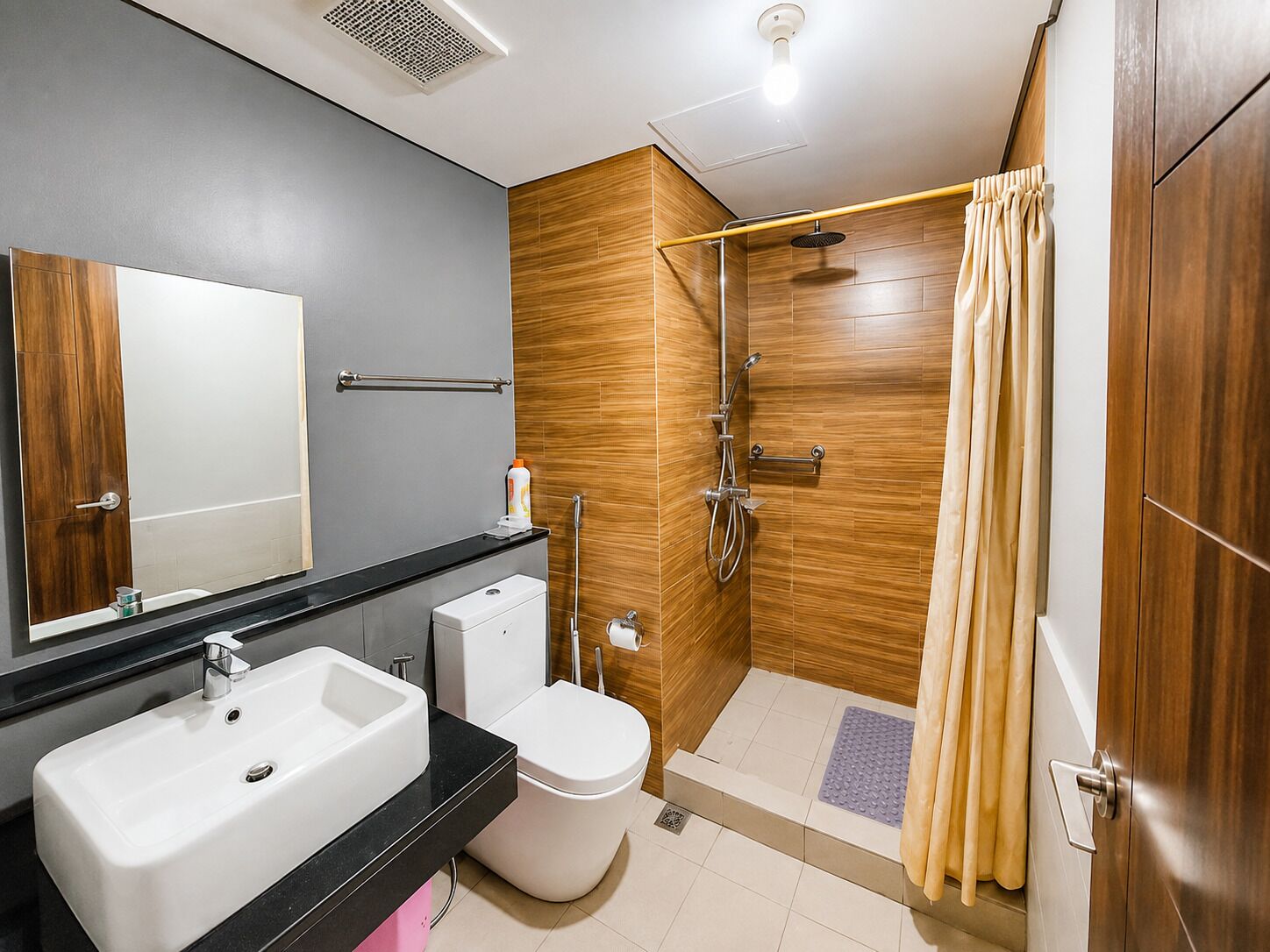Un baño moderno con ducha, inodoro y dos lavamanos.