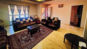 Un salon avec un canapé, une table basse et un tapis à motifs.