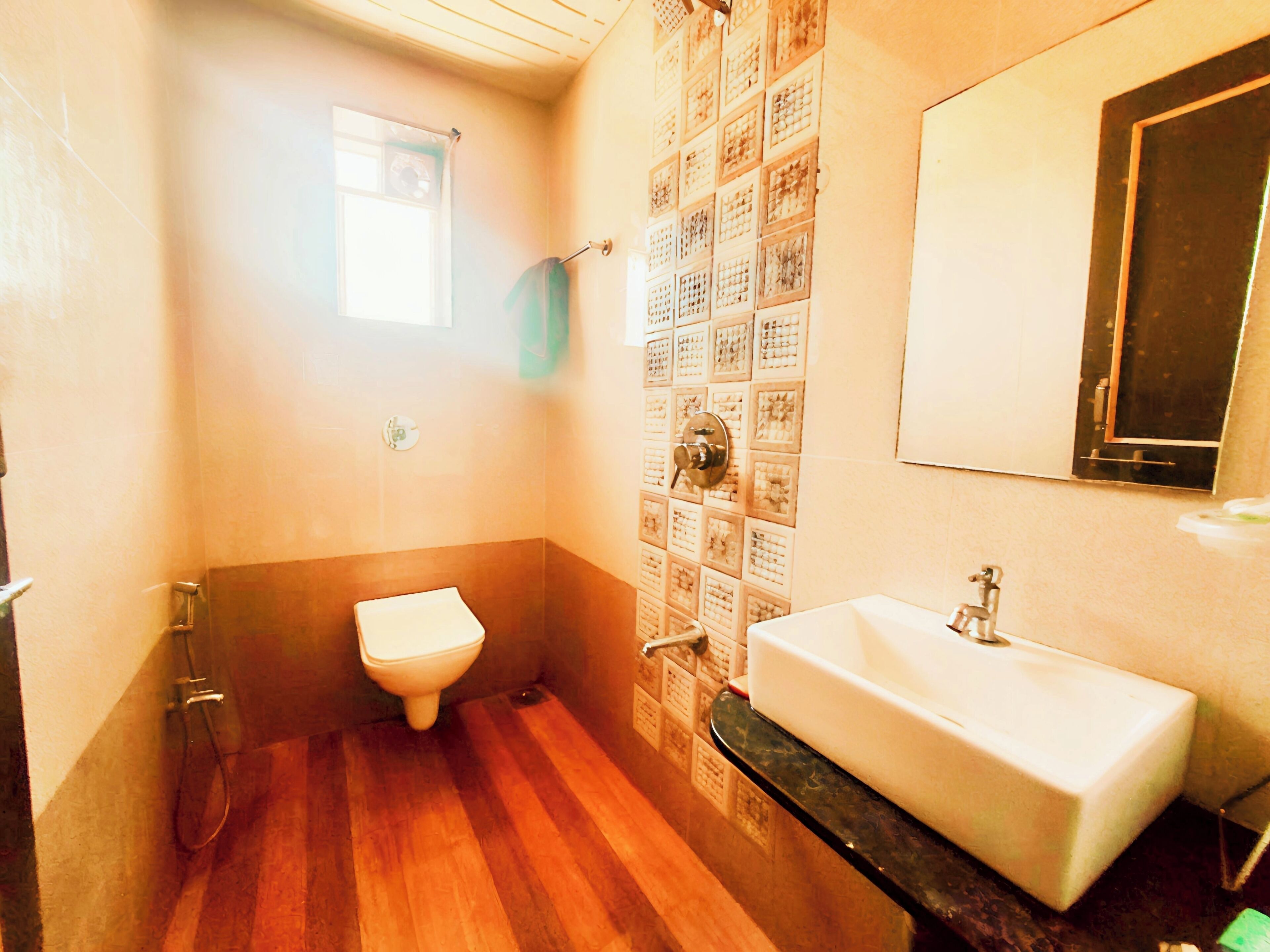 A bathroom with a toilet, sink, and a tiled shower area.