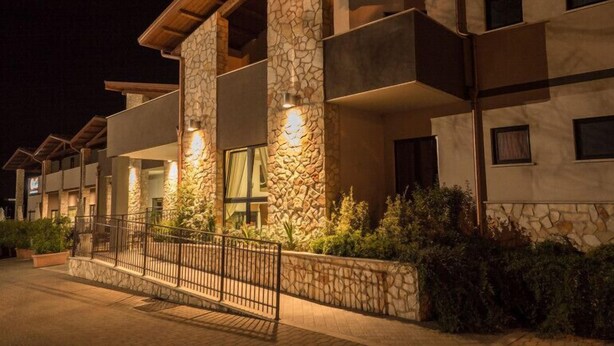 A multi-story hotel with stone facade, balconies, and a gated entrance. - Hotel Centova (Perugia)